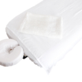 Pure white cotton blanket folded on massage table